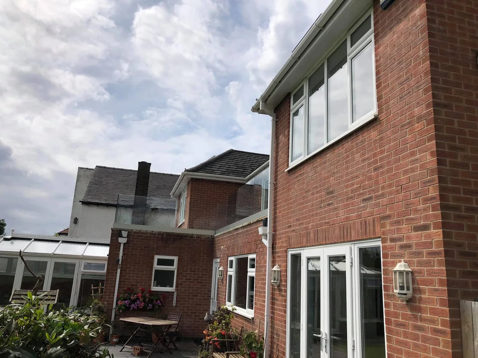 A brick house with a conservatory, windows and frames cleaned